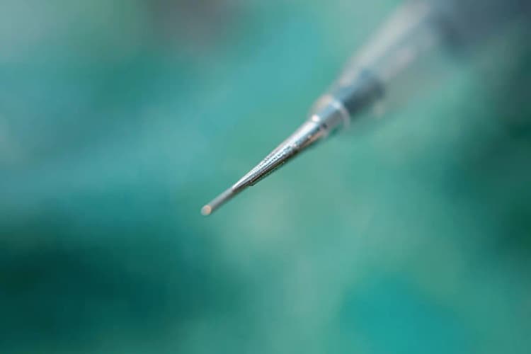 Um close-up de um aplicador de injeção com uma agulha fina em um fundo desfocado.