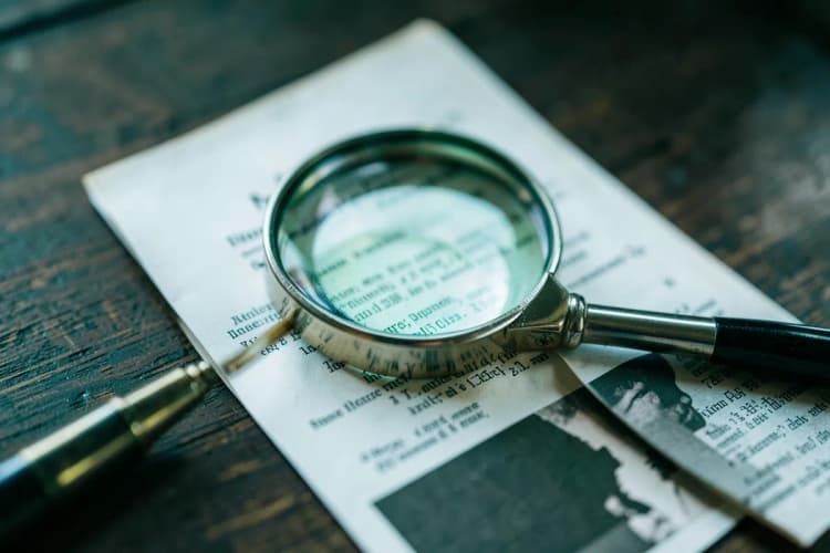 Uma lupa examinando um documento legal em uma mesa de madeira.