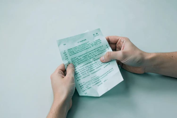 Uma pessoa examinando um documento com informações sobre o SUS em uma mesa.