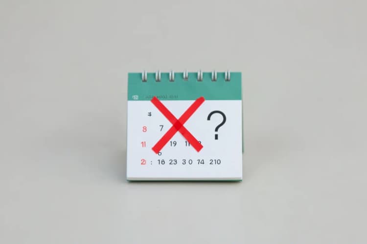um calendário com um X vermelho sobre ele e um ponto de interrogação ao lado