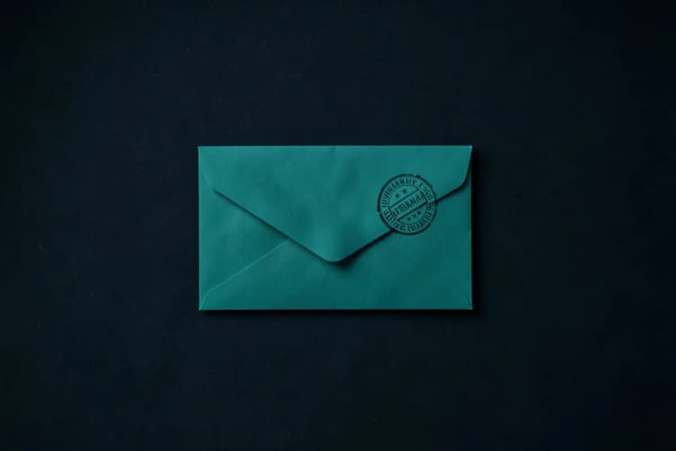 Um envelope selado com um carimbo de "permanente" em um fundo escuro.