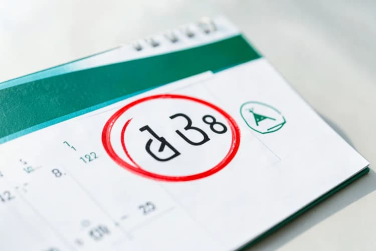Um calendário com um dia marcado em vermelho e um símbolo de alerta, indicando um bloqueio temporário.