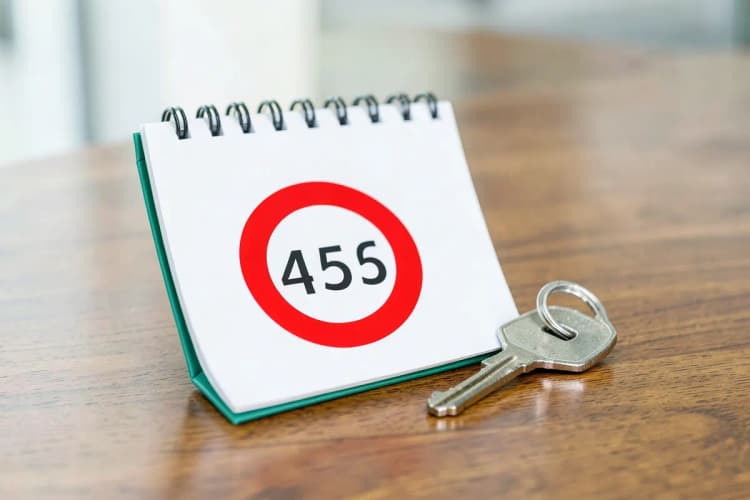 Um calendário com a data marcada em vermelho e uma chave de casa ao lado, simbolizando o atraso na entrega.