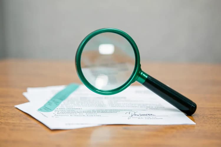 Uma pessoa examinando um contrato de time-share com uma lupa, focando em cláusulas específicas.