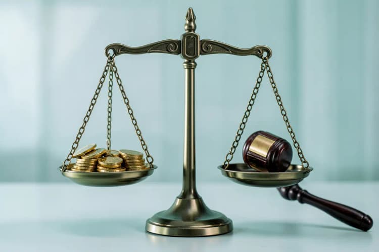 Uma balança de justiça com uma pilha de moedas de ouro de um lado e um martelo de juiz do outro.