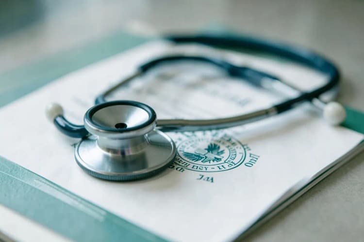 Um close-up de um estetoscópio sobre um documento médico com um selo oficial.