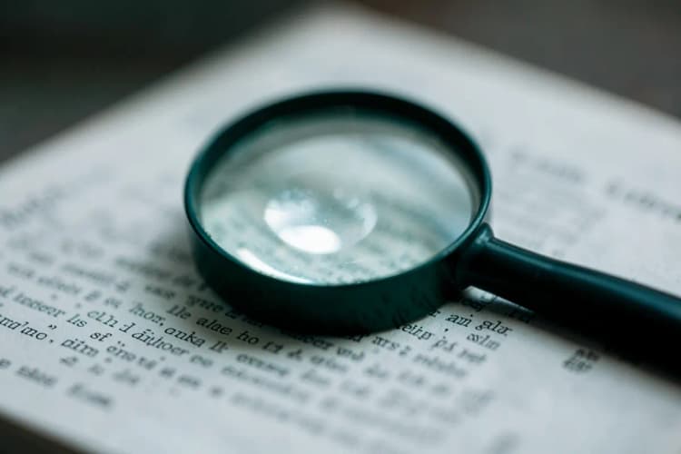 Uma lupa sobre um documento com texto, em close-up.