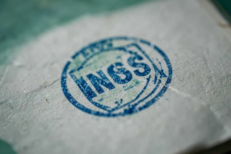 Um close-up de um carimbo oficial do INSS em um documento, com foco na tinta azul.