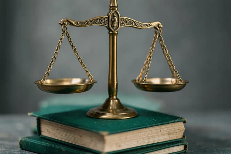 Uma balança de justiça em cima de livros, simbolizando a avaliação médica.
